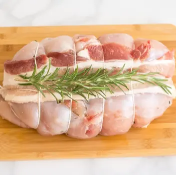 Faraona ripiena vista dall'alto con foglia di alloro su tavolo di legno