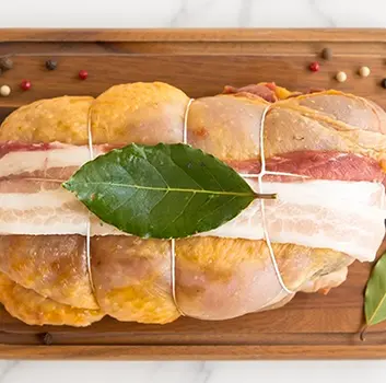 Faraona ripiena vista dall'alto con foglia di alloro su tavolo di legno